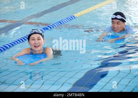 Couple senior japonais à la piscine intérieure Banque D'Images