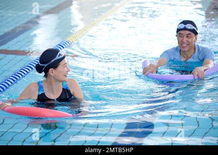 Couple senior japonais à la piscine intérieure Banque D'Images