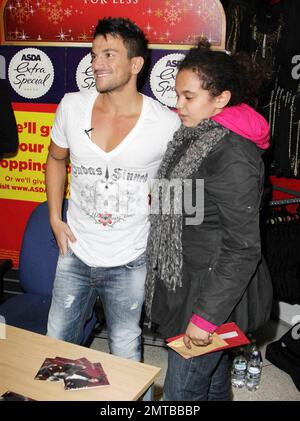 Le chanteur de pop Peter Andre pose avec un CD de son dernier single « Defender » et avec des fans au centre commercial Asda dans l'ouest de Londres lors d'une signature de CD. Les fans d'Andre sont arrivés aussi tôt que huit heures la nuit avant et ont campé dehors pour être à l'avant de la ligne. Le chanteur de 36 ans, qui portait un bandaid sur son doigt de mariage, a récemment éludé les questions concernant sa vie amoureuse et une rumeur de romance avec une ancienne assistante de son ex-femme Katie Price. Londres, Royaume-Uni. 10/26/10. Banque D'Images