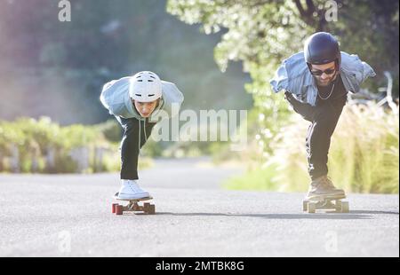 Amis, vitesse et patinage de longue durée sur route, course en descente avec skateboard et casque pour la sécurité. Aventure sportive extrême, skate Street Banque D'Images