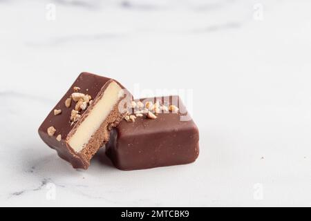 Bonbons faits main au chocolat et morceaux de bonbons coupés avec praline et truffe sur fond blanc avec photo horizontale d'espace de copie Banque D'Images