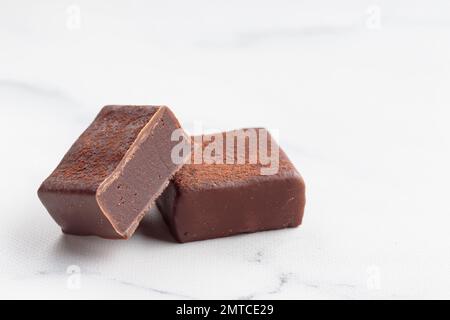 Bonbons faits main au chocolat et morceaux de bonbons coupés avec praline et truffe sur fond blanc avec photo horizontale d'espace de copie Banque D'Images