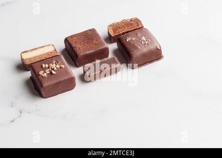 Bonbons faits main au chocolat et morceaux de bonbons coupés avec praline et truffe sur fond blanc avec photo horizontale d'espace de copie Banque D'Images