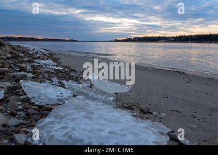 De petits morceaux de glace se trouvent sur la rive sablonneuse de la rivière Vilyuy au début de l'hiver. Banque D'Images