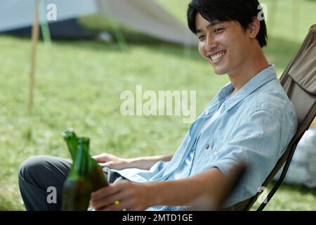 Jeune homme japonais au camping Banque D'Images