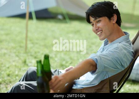 Jeune homme japonais au camping Banque D'Images