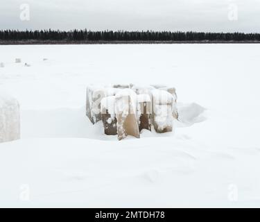 Glace sculptée pour manger des piliers couverts de neige en tas sur la rivière Vilyui à Yakutia en hiver, sur fond d'une forêt de taïga. Banque D'Images