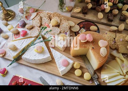 Fromages et macarons sur la table, bar à bonbons de mariage de luxe. ROSE BLUSH NATURE MORTE Banque D'Images