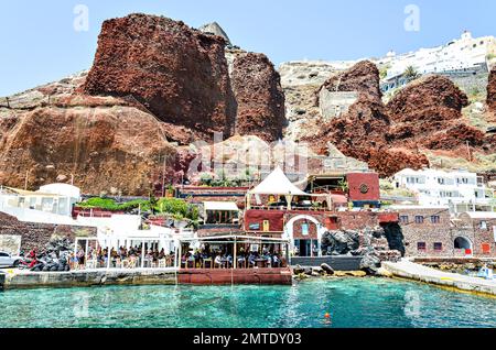 Oía, Santorini, Grèce; 22 juin 2022: Baie d'Ammoudi, Port d'Oia avec ses terrasses sur la rive et ses bateaux de pêche Banque D'Images