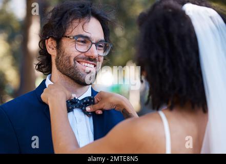 Mariage, couple heureux et noeud papillon extérieur à l'événement de célébration de mariage avec soin. Sourire de marié et de mariée dans un parc avec amour, partenariat Banque D'Images