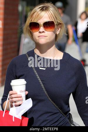 Lors d'un après-midi ensoleillé, l'actrice Reese Witherspoon, dans une jupe et un chandail fleuris à plusieurs niveaux, est sortie pour prendre un café et quelques chocolats suisses du chocolatier Teuscher. Le collier délicat que Reese portait est un rappel affectueux de ses enfants comme il lit 'Ava' et 'Deacon'. Los Angeles, Californie. 03/08/11. Banque D'Images