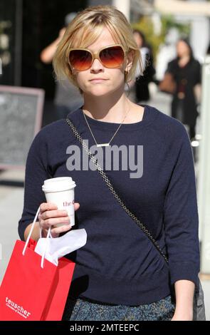 Lors d'un après-midi ensoleillé, l'actrice Reese Witherspoon, dans une jupe et un chandail fleuris à plusieurs niveaux, est sortie pour prendre un café et quelques chocolats suisses du chocolatier Teuscher. Le collier délicat que Reese portait est un rappel affectueux de ses enfants comme il lit 'Ava' et 'Deacon'. Los Angeles, Californie. 03/08/11. Banque D'Images