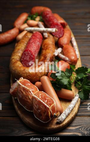 Différentes saucisses savoureuses sur une table en bois, en gros plan Banque D'Images