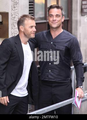 Robbie Williams et Gary Barlow arrivent à BBC radio One pour le salon de petit-déjeuner Chris Moyles. Ils ont avoué qu'ils sortiront et feront la promotion d'un album en novembre et se sont donné un grand hug pour montrer que les désaccords précédents sont dans le passé, Londres, Royaume-Uni, 08/26/10. Banque D'Images