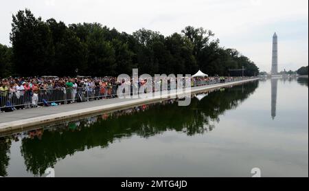 FILE - In this Aug. 28, 2013 photo, people gather around the reflecting pool, looking toward the Washington Monument, near the Lincoln Memorial in Washington. The National Park Service says it's draining the Lincoln Memorial Reflecting Pool for cleaning and treatment. Officials said in a statement that the draining will begin Sunday, June 11, 2017, and the pool should be refilled and operational on June 19. They say the pool's cleaning comes after a water-borne parasite affected the local duck population. (AP Photo/Susan Walsh, File)