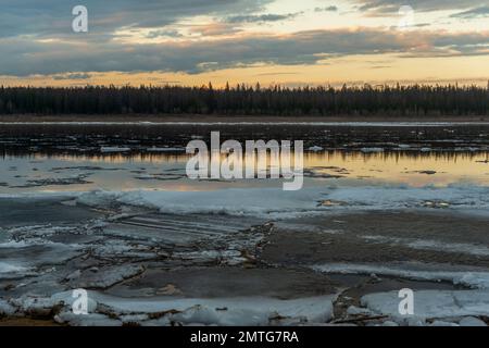 Les restes de la dernière glace printanière sur la rivière Vilyui fondent près de la rive dans l'eau. Banque D'Images