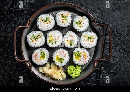 Gimbap de Kimbap rempli de légumes, d'œufs, d'anchois et de crabe, roulades de riz coréennes. Arrière-plan noir. Vue de dessus. Banque D'Images