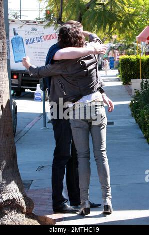 EXCLUSIF !! Le comédien britannique Russell Brand pose avec des fans et donne un câlin à un ami pendant son déjeuner dans un café de Los Feliz. Russell porte fièrement son anneau d'engagement montrant qu'il est toujours très amoureux de Katy Perry, fiancée, chanteuse pop américaine. Russell porte également ses vêtements sauvages typiques, un Jean skinny à enfiler, des bottes à talons et une veste de moto grise de style 80s. Los Angeles, Californie. 04/06/10. Banque D'Images