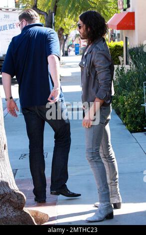 EXCLUSIF !! Le comédien britannique Russell Brand pose avec des fans et donne un câlin à un ami pendant son déjeuner dans un café de Los Feliz. Russell porte fièrement son anneau d'engagement montrant qu'il est toujours très amoureux de Katy Perry, fiancée, chanteuse pop américaine. Russell porte également ses vêtements sauvages typiques, un Jean skinny à enfiler, des bottes à talons et une veste de moto grise de style 80s. Los Angeles, Californie. 04/06/10. . Banque D'Images