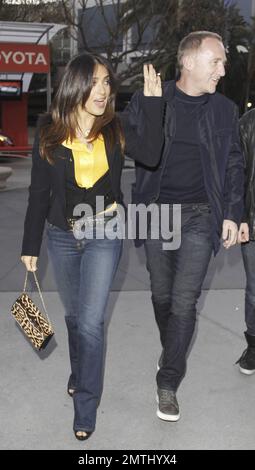 Portant un haut jaune vif, une veste noire, un Jean bleu, des talons hauts noirs et un sac à main à imprimé animal, l'actrice Salma Hayek et son mari François-Henri Pinault ont été vus arriver au Staples Center pour un match Lakers contre le San Antonio Spurs. Los Angeles, Californie. 17th avril 2012. Banque D'Images