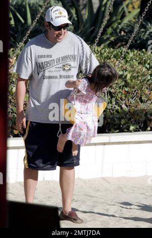 L'acteur Adam Sandler et la famille passent ensemble les vacances de la fête du travail à Malibu Country Mart. Pendant la journée, Sandler a pris le temps de pousser sa fille plus jeune Sunny sur le balançoire. Malibu, Californie 5th septembre 2011. . . Banque D'Images