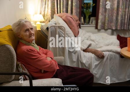 Couple âgé dans les années 80 ensemble dans une chambre à coucher de maison de retraite de résidents, Angleterre, Royaume-Uni Banque D'Images