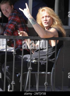 EXCLUSIF !! Canadien rocker et ancien leader du groupe Skid Row, Sebastian Bach fait clignoter les cornes du diable comme s'il était bon de dire bonjour aux paparazzi tout en dégustant un déjeuner dans un café extérieur. Los Angeles, Californie. 01/27/11. Banque D'Images