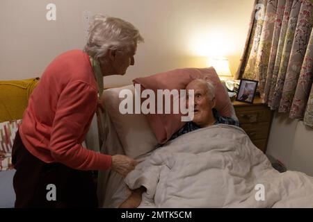 Couple âgé dans les années 80 ensemble dans une chambre à coucher de maison de retraite de résidents, Angleterre, Royaume-Uni Banque D'Images