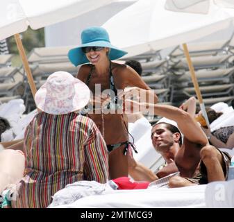 Exclusif !! Jamais l'exhibitionniste Shauna Sand change de bikinis dans la vue sur Miami Beach. L'ex Playmate astucieux a acheté un nouveau bikini d'un vendeur de plage et a mis le nouveau camouflage sur son vieux rose. Puis son copain masculin l'a aidée à enlever l'ancien avant d'aller pour une poule mouillée dans le surf, Miami Beach, FL, 4/24/08. Banque D'Images