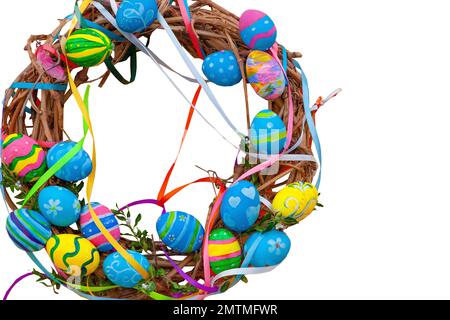 Couronne de Pâques de vignes et d'oeufs colorés isolés sur fond blanc. Décoration festive à la porte et dans la maison. Décoration printanière. Œuf bleu jaune décoré. Couronne de branches de saule Banque D'Images