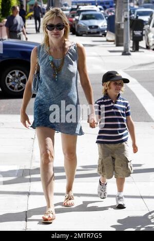 Portant une robe bleue simple et des sandales, Sharon Stone emmène son fils Laird à Color Me Mine où elle l'aide à peindre sa propre voiture de course. Les deux semblent avoir un bon moment ensemble de travailler sur le projet. Beverly Hills, Californie. 8/26/10. Banque D'Images