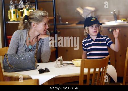 Portant une robe bleue simple et des sandales, Sharon Stone emmène son fils Laird à Color Me Mine où elle l'aide à peindre sa propre voiture de course. Les deux semblent avoir un bon moment ensemble de travailler sur le projet. Beverly Hills, Californie. 8/26/10. Banque D'Images
