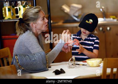 Portant une robe bleue simple et des sandales, Sharon Stone emmène son fils Laird à Color Me Mine où elle l'aide à peindre sa propre voiture de course. Les deux semblent avoir un bon moment ensemble de travailler sur le projet. Beverly Hills, Californie. 8/26/10. Banque D'Images