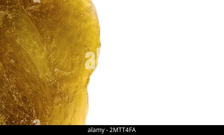 Texture du produit cosmétique jaune transparent isolée sur fond blanc. Pâte de sucre jaune liquide ou cire pour l'épilation de près. Banque D'Images