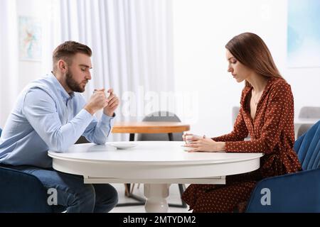 Couple avec des problèmes de relation à la table dans le café Banque D'Images