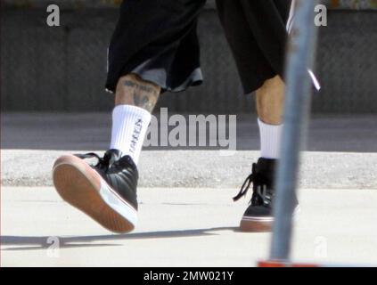 EXCLUSIF !! Quelques jours après le premier anniversaire d'un accident d'avion presque mortel, Travis Barker a été repéré entrant dans son bus touristique portant une paire de pantalons qui ont révélé ses jambes brûlées. Le batteur Blink-182 a subi des brûlures à 3rd degrés sur toute la moitié inférieure de son corps et ses mains pendant l'accident. Barker a tragiquement perdu son cosurvivant et son bon ami DJ AM à une overdose il y a près d'un mois et a coupé une triste figure alors qu'il a quitté son hôtel pour préparer un concert plus tard dans la nuit au Cruzan Amphitheater. Palm Beach, Floride. 9/26/09. Banque D'Images