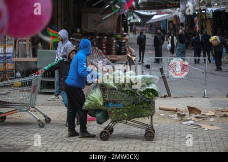 Un travailleur palestinien pousse une voiturette de transport de ramassage au milieu de la rue dans le camp de réfugiés de Jabalia lors des intempéries dans la ville de Gaza, à 1 février 2023. Photo de Ramez Habboub/ABACAPRESS.COM Banque D'Images