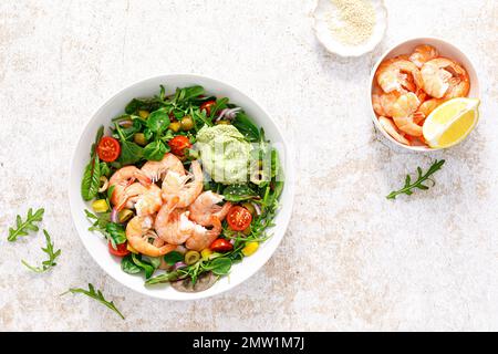 Salade de crevettes et légumes-feuilles avec tomate, poivron, sauce olive et avocat. Vue de dessus Banque D'Images