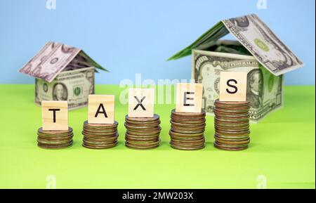 Taxes sur les mots sur les blocs de mots en bois sur les quartiers empilés avec des maisons de monnaie Banque D'Images