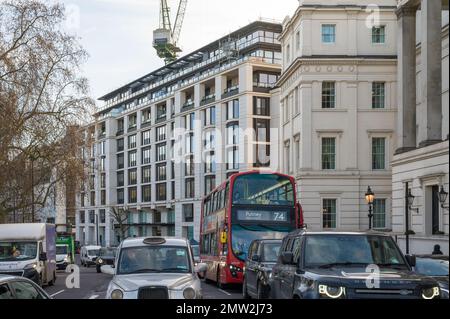 Vue sur Grosvenor place depuis Hyde Park Corner vers le Peninsula Hotel, récemment construit. Circulation dense sur la route. Londres, Angleterre, Royaume-Uni. Banque D'Images