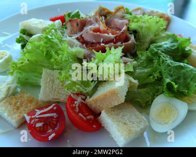 Assiette de salade de viande servie avec du pain grillé, de la tomate et du fromage râpé sur une assiette blanche photo haute résolution détaillée Banque D'Images