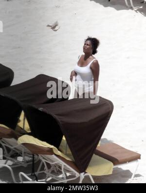 EXCLUSIF !! La chanteuse R&B Whitney Houston, vêtue d'un maillot de bain blanc pour montrer sa silhouette plus pleine, aime passer un après-midi à la plage d'Atlantis Paradise Island avec sa fille de 17 ans, Bobbi Kristina, et ses amis. Houston, qui a 47 ans en deux jours sur 9 août, a apprécié un hot-dog et une boisson gazeuse avant de se couvrir sous sa serviette alors qu'elle pointait à l'intérieur de son hôtel de luxe. Nassau, Bahamas 08/07/2010 . Banque D'Images