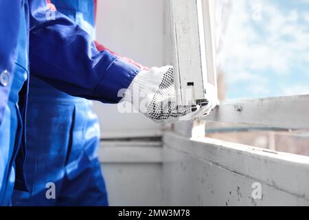 Ouvriers démontant l'ancienne fenêtre à l'intérieur, vue rapprochée Banque D'Images