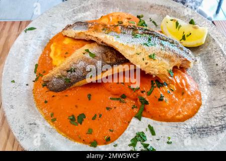 Vue de dessus du plat italien de bar sur la sauce tomate. Banque D'Images