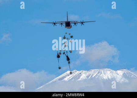 Préfecture de Shizuoka, Japon. 31st janvier 2023. Les parachutistes de la Force d'autodéfense du Japon avec la Brigade aéroportée 1st descendent d'un avion C-130J Super Hercules de la Force aérienne des États-Unis avec le Mont Fuji enneigé derrière, dans la zone de manœuvre du Fuji est, à 31 janvier 2023, à Honshu, au Japon. Crédit : Yasuo Osakabe/États-Unis Air Force/Alamy Live News Banque D'Images