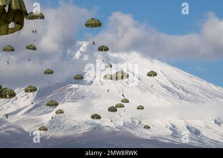 Préfecture de Shizuoka, Japon. 31st janvier 2023. Les parachutistes de la Force d'autodéfense du Japon avec la Brigade aéroportée 1st descendent d'un avion C-130J Super Hercules de la Force aérienne des États-Unis avec le Mont Fuji enneigé derrière, dans la zone de manœuvre du Fuji est, à 31 janvier 2023, à Honshu, au Japon. Crédit : Yasuo Osakabe/États-Unis Air Force/Alamy Live News Banque D'Images