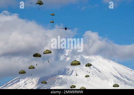 Préfecture de Shizuoka, Japon. 31st janvier 2023. Les parachutistes de la Force d'autodéfense du Japon avec la Brigade aéroportée 1st descendent d'un avion C-130J Super Hercules de la Force aérienne des États-Unis avec le Mont Fuji enneigé derrière, dans la zone de manœuvre du Fuji est, à 31 janvier 2023, à Honshu, au Japon. Crédit : Yasuo Osakabe/États-Unis Air Force/Alamy Live News Banque D'Images