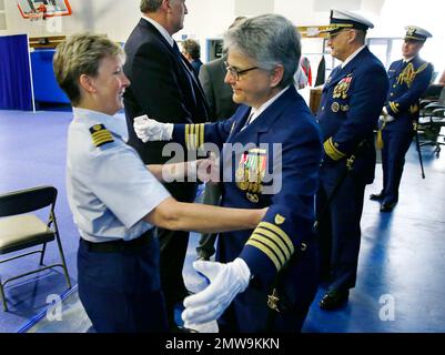 Capt. Linda Sturgis, center, the new commander of the U.S. Coast Guard's Sector Puget Sound, hugs her wife, Capt. Monica Rochester, left, who is the deputy commander of USCG Sector Los Angeles Long Beach, following a change of command ceremony, Friday, March 10, 2017, in Seattle. Sturgis took over command from Capt. Joe Raymond. (AP Photo/Ted S. Warren)