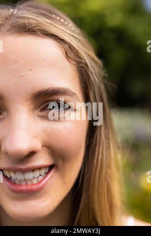 Portrait vertical en gros plan de la mariée caucasienne avec les yeux verts dans le jardin lors du mariage en plein air Banque D'Images