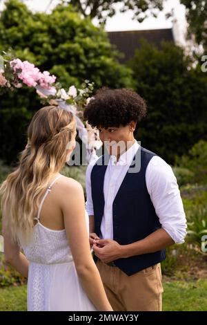 Vertical de la mariée et marié heureux divers faisant des voeux de mariage à l'extérieur de mariage Banque D'Images